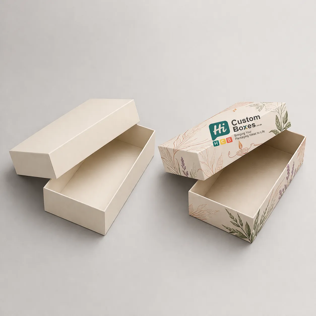 Two elongated two-piece gift boxes, one plain cream and one decorated with delicate botanical line art. class=